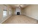 Living room with neutral carpet, fireplace, and built-ins, complemented by ample natural light from the large windows at 8471 Penton Pl, Harrisburg, NC 28075