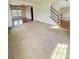 Spacious living room with staircase and entry to the dining room featuring elegant hardwood flooring and windows at 8471 Penton Pl, Harrisburg, NC 28075