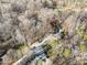 Aerial view of a home with a pool situated in a wooded lot at 1006 Lost Cv, Weddington, NC 28104