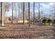 Spacious backyard with mature trees and a glimpse of the pool and gazebo at 1006 Lost Cv, Weddington, NC 28104