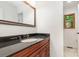 Bathroom featuring a black countertop, decorative mirror, vanity, and wood cabinets at 1006 Lost Cv, Weddington, NC 28104