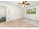 Bright bedroom featuring two windows, carpet flooring, ceiling fan, and a walk-in closet at 1006 Lost Cv, Weddington, NC 28104