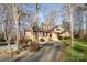 Long gravel driveway leads to a brick home nestled among mature trees, offering privacy and curb appeal at 1006 Lost Cv, Weddington, NC 28104