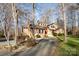 Charming brick and siding home with a bright red front door nestled amongst mature trees at 1006 Lost Cv, Weddington, NC 28104