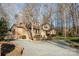 Beautiful home showcasing a long driveway and lush landscaping surrounded by mature trees at 1006 Lost Cv, Weddington, NC 28104
