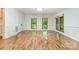 Bright living room with hardwood floors, three large windows, and white wainscoting at 1006 Lost Cv, Weddington, NC 28104