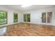 Living room showcasing hardwood floors, large windows, and a glass patio door at 1006 Lost Cv, Weddington, NC 28104