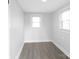 This small bedroom has gray floors, neutral walls, and two windows at 1110 Alexander St, Statesville, NC 28677