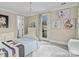Bright bedroom features a chandelier, soft decor, and access to a small balcony at 1238 Ladera Dr, Waxhaw, NC 28173