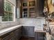 Butler's pantry with dark cabinets, gold hardware, marble countertops, and a window providing natural light at 1238 Ladera Dr, Waxhaw, NC 28173