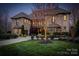 Stunning stone home boasting lush landscaping, a well-lit driveway, and inviting architecture at 1238 Ladera Dr, Waxhaw, NC 28173