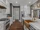 Bright kitchen featuring white cabinets, stainless appliances, wood flooring, and marble countertops at 1238 Ladera Dr, Waxhaw, NC 28173