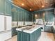 Gorgeous kitchen with a wood plank ceiling, green cabinets with gold trim, and marble countertops and backsplash at 1238 Ladera Dr, Waxhaw, NC 28173