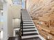 Staircase featuring wood accent wall, white risers and black treads, leading to the upper level at 1238 Ladera Dr, Waxhaw, NC 28173