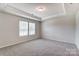 Bright bedroom featuring a tray ceiling and large window at 14726 Tamarack Dr, Charlotte, NC 28278
