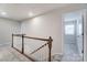 Bright hallway featuring wood railing and neutral carpet at 14726 Tamarack Dr, Charlotte, NC 28278