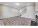 Large living room with wood-look floors, a fireplace, and stairs to the upper level, offering ample space at 14726 Tamarack Dr, Charlotte, NC 28278