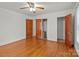 Bedroom with hardwood floors, white walls, ceiling fan, walk-in closet and a small door to another room at 1489 Riley St, Albemarle, NC 28001