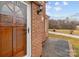 Front door featuring brick exterior with window panes, with a trimmed lawn at 1489 Riley St, Albemarle, NC 28001