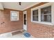 Enclosed front porch featuring brick walls and a view of the front yard at 1489 Riley St, Albemarle, NC 28001
