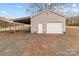 A detached garage with a roll-up door and covered carport offers ample parking at 1489 Riley St, Albemarle, NC 28001