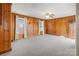 Cozy living room with wood paneling, neutral carpet, and inviting natural light at 1489 Riley St, Albemarle, NC 28001