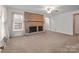 Spacious living room featuring a brick fireplace, carpet flooring, and ample natural light at 1489 Riley St, Albemarle, NC 28001