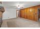 Spacious living room with wood paneling, carpeted floors, and a ceiling fan at 1489 Riley St, Albemarle, NC 28001