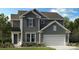 Charming two-story home with gray siding, a front lawn, an attached garage and manicured landscaping at 1498 Hubert Graham Way, Tega Cay, SC 29708