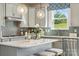 Well-lit kitchen with light gray cabinetry, a center island, and stainless steel appliances at 1498 Hubert Graham Way, Tega Cay, SC 29708