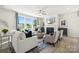 Comfortable living room with a fireplace, large windows, and neutral-colored furnishings at 1498 Hubert Graham Way, Tega Cay, SC 29708