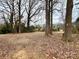Spacious backyard featuring mature trees providing shade and privacy on a cloudy day at 1936 Russell Ave, Charlotte, NC 28216