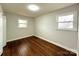 Light-filled bedroom featuring hardwood floors, neutral walls, and two bright windows at 1936 Russell Ave, Charlotte, NC 28216