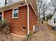 Side view of a red brick home with a white gutter and surrounded by a leafy yard at 1936 Russell Ave, Charlotte, NC 28216