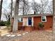 Charming brick home featuring a welcoming blue door and a well-maintained front yard at 1936 Russell Ave, Charlotte, NC 28216