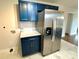 Modern kitchen featuring stainless steel refrigerator, blue cabinetry, and white countertops at 1936 Russell Ave, Charlotte, NC 28216