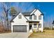 Beautiful two-story home with white brick, black trim, and a two-car garage at 2143 Country Club Rd, Lincolnton, NC 28092