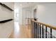 Hallway with light wood floors, wood and metal railings, floating shelves, and neutral walls at 2143 Country Club Rd, Lincolnton, NC 28092