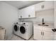 Bright laundry room with white cabinets, modern appliances and a utility sink at 2143 Country Club Rd, Lincolnton, NC 28092