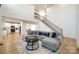 Open concept living room with gray sectional sofa, hardwood floors, and modern staircase at 2143 Country Club Rd, Lincolnton, NC 28092