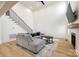 Bright living room with a gray sectional sofa, tall ceilings, and a modern staircase at 2143 Country Club Rd, Lincolnton, NC 28092