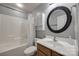 A bathroom with a sink, a round mirror, a toilet, a shower and tub combo, and cabinet storage at 226 Belfield Ln, Fort Mill, SC 29715