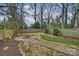 Backyard features a stone fire pit, lush landscaping, a privacy fence and mature trees at 3126 Creighton Dr, Charlotte, NC 28205