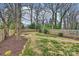 Large backyard with a firepit, brick pathway, well-kept lawn, and mature trees at 3126 Creighton Dr, Charlotte, NC 28205