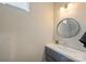 Modern half bathroom features a round mirror and a sleek vanity with a light-gray cabinet at 3126 Creighton Dr, Charlotte, NC 28205