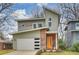 Contemporary two-story home featuring a stylish orange front door, white garage door, and unique architectural details at 3126 Creighton Dr, Charlotte, NC 28205