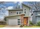 Contemporary two-story home featuring a stylish orange front door, white garage door, and unique architectural details at 3126 Creighton Dr, Charlotte, NC 28205