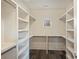 Bright walk-in closet with custom white shelving and dark wood floors offers ample storage space at 3126 Creighton Dr, Charlotte, NC 28205