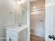 Bathroom with a large mirror, white cabinets, and a view into a tiled shower area at 3213 Mcharney Dr # 32, Harrisburg, NC 28075