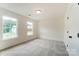 Bright bedroom with neutral carpet, two windows letting in natural light, and a ceiling light fixture at 3213 Mcharney Dr # 32, Harrisburg, NC 28075